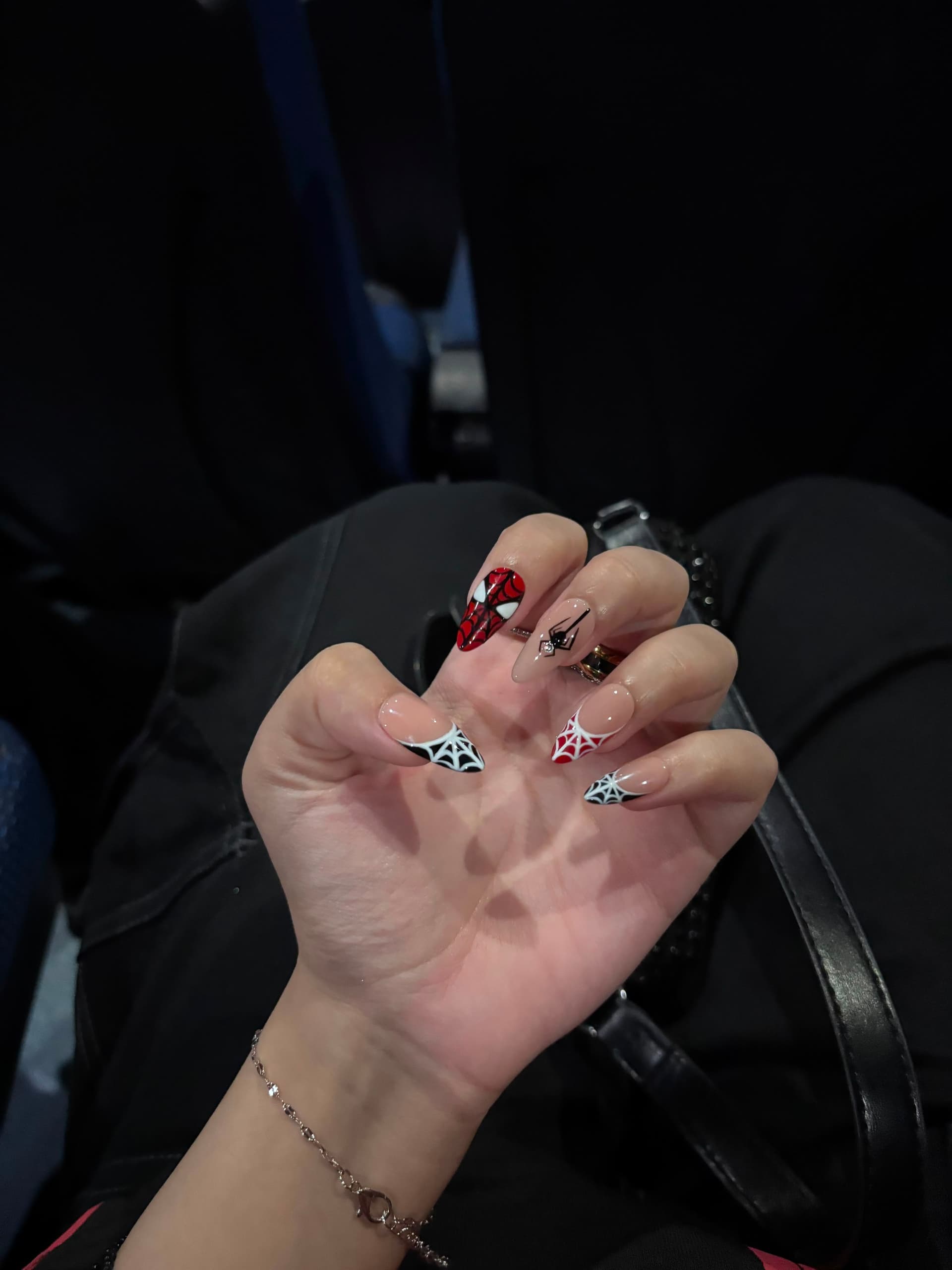 A spider web french set on long stiletto nails, worn