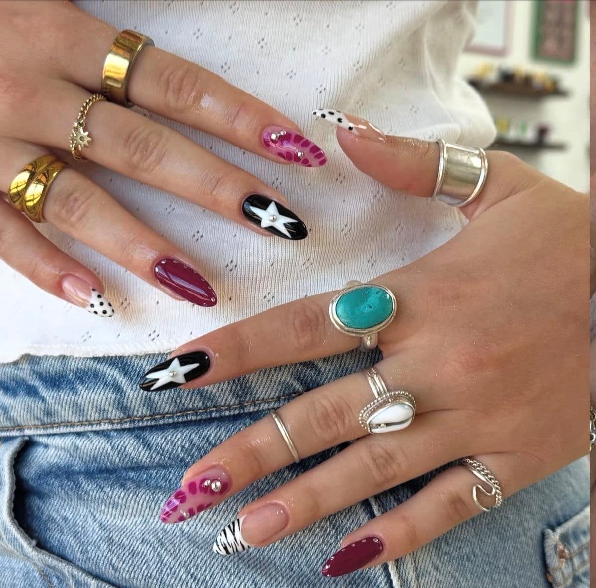 Two hands wearing hand-painted press-on sets in several designs