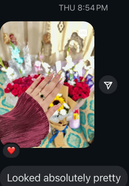 A customer photographs her set beside a bouquet of roses